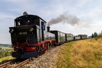 Dampflok wieder in Betrieb: Warum ein Verein im Erzgebirge jahrelang auf sein Zugpferd warten musste - Die Dampflok 99582 auf Fahrt. In den Aussichtswagen waren die Gäste gestiegen, die bei ihrer offiziellen Wiederinbetriebnahme anwesend waren.