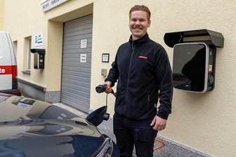 Dank Sonne: Auerbacher Unternehmer erzeugt ein Drittel des Strombedarfs künftig selbst - Medimax-Mitarbeiter Domenic Wunderlich macht gut gelaunt vor, wie es gehen könnte: Stecker rein, Strom ins E-Auto fließen lassen, wieder losfahren. 