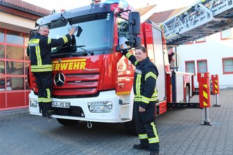 Darum ist das Feuerwehrfest in Flöha diesmal kürzer - Putzen für das Feuerwehrfest in Flöha: Marcel Grünert (l.) und Colin Auerbach machen die neue Drehleiter schick.