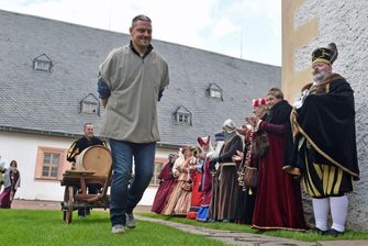 Die Knechte Tim Laßner (vorne) und Franz Vieweger schaffen das neue Fass heran.