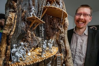 Das Erbe des Erzgebirges in Metall gegossen – Museum zeigt besondere Schau - Museumsleiter Lasse Eggers zeigt die Exponate der Ausstellung vor ihrer hölzernen Kulisse.
