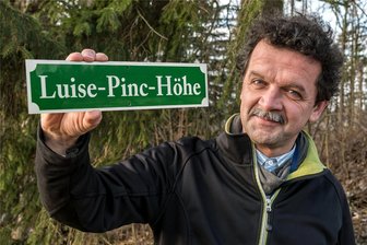 Das Erzgebirge schreibt Geschichte: Wenn eine Stadt die andere überholt - Der Marienberger René Schubert mit dem Schild, das er gern am Wegesrand auf der Höhe bei Satzung anbringen lassen möchte, um an die berühmte Tochter des Orts zu erinnern.