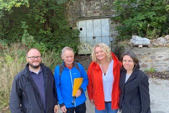 Das Geheimnis der Militärbunker von Lengenfeld: Zwei Wunder, von denen kaum noch jemand weiß - Vor einem der Tore der längst verschlossenen und versteckt liegenden Rüstungs- und Militärstollen von Lengenfeld. Zeitzeuge Volker Sönnichsen (mit gelbem Hefter) mit Vertretern des Vereins Stadtleben, von rechts: Katja Körner, Katrin Reichel und Torsten Reichel.