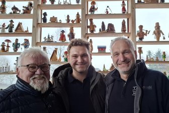 Das gibt‘s nur im Erzgebirge: Diese Männer retten betagte Räuchermännchen - Rolf Höfer sowie Florian und Lutz Kunze (v. l.) vor der Räuchermännelwand auf der Terrasse, die nach Lichtmess aber wieder abgebaut wird. Die hölzernen Senioren im Gastraum indes bleiben in „Räuchermännelsruh 2.0“ stehen.