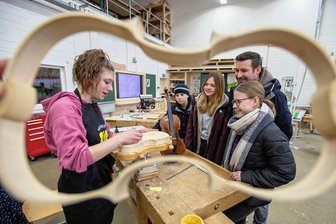 Das Handwerk im Vogtland gewinnt mehr junge Menschen für eine Ausbildung - Lydia Rohloff (18), angehende Geigenbauerin im zweiten Lehrjahr, war gefragte Gesprächspartnerin. Konrad Spörl, Lea Hommel (17), Andreas sowie Hannah Spörl (15/von links) verfolgten die Handgriffe fasziniert. 