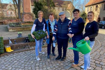 „Das Herz wird nicht dement“: Wie Wechselburgs Pflegeeinrichtungen den Alltag mit Demenzkranken meistern - Cathleen Matthes (l.), Elisa Zwinzscher (.) und Conny Grahm (2. v. r.) haben die Pflanzaktion in Wechselburg organisiert, um an Demenz zu erinnern. Christian Hentschel ist daran erkrankt, seine Frau Heidrun pflegt ihn.