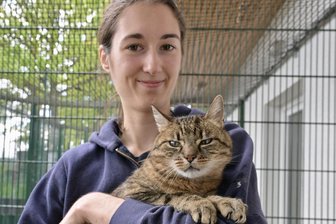 „Das ist beschämend“: Fördergeld vom Freistaat Sachsen für Tierschutz soll halbiert werden - Mitarbeiterin Vanessa Kemnitzer hält im Tierheim Vielau einen ihrer pelzigen Schützlinge auf dem Arm.