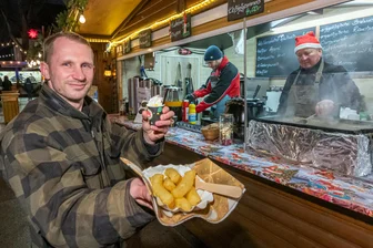 Das kosten Glühwein, Bratwurst und gebrannte Mandeln auf dem Weihnachtsmarkt in Marienberg - An der Bude von Jörg Kleditzsch (l.) gibt es unter anderem Kloßteig-Pommes und Bombardino. Hinten im Bild: Joachim Horn (r.) und Erik Brandt.