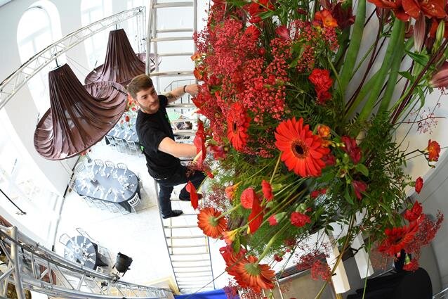 Das Opernhaus blüht für den Ball auf - Phillip Heinze, Auszubildender im Gartenfachmarkt Richter, kletterte für das Anbringen der Blumendeko auf die Leiter. Die Gestecke alleine sind zwei Meter lang und hängen meterhoch über den Gästen.