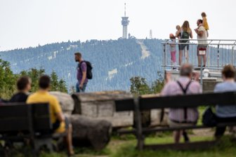 „Das Problem liegt ganz woanders“ – Touristiker reagieren gelassen auf Debatte um Rechtsruck in Aue - Besucher des Fichtelbergs genießen den Ausblick. Der 1215 Meter hohe Berg ist im Sommer wie auch im Winter ein Anziehungspunkt für zahlreiche Urlauber in der Region.