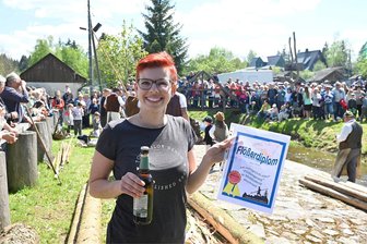 Das Schauflößen in Muldenberg lockt zahlreiche Besucher an: Wofür es viel Applaus gab - Annabell Stasch aus Tirpersdorf erhielt für ihren gelungenen Flößersprung ein Diplom, ein Kaltgetränk und viel Beifall von den Schaulustigen.