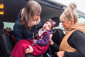 Deborahs Familie sehnt ihren Umzug ins Haus herbei - Keine leichte Angelegenheit: Romy Wohlgemuth muss Deborah aus dem Kindersitz (rechts: Fahrerin Katrin Köhler) heben und sie dann ins Haus tragen.