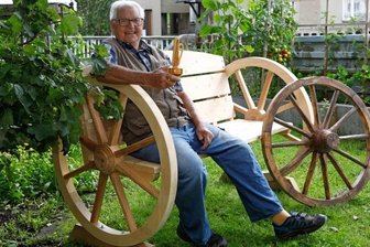 Den Stellmacher hält sein Handwerk jung - Egon Reinhold auf der kürzlich gebauten Bank. In der Hand hält er eine der Vasen, die er früher hundertfach gefertigt hat. 