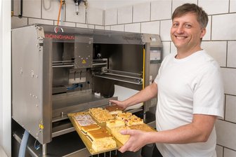 Der Bewahrer einer 120-jährigen Tradition im Erzgebirge: Bäckermeister Schmieder übernimmt Heidersdorfer Unternehmen - Neueste Technik für den perfekten Schnitt: Bäckermeister Marcel Schmieder vor dem Ultraschall-Kuchenschneider. Das Gerät zählt zu den jüngsten Investitionen im Unternehmen. Es schneidet nicht nur präzise, sondern entlastet auch die Belegschaft.