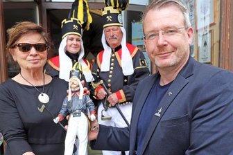 Der dreifache Bergakademist - Iris Thiele (links) und Sven Krüger (rechts) präsentieren Bergakademisten in drei Größen: ganz klein am Revers des OB, klein und aus Holz in ihren Händen und in Fleisch und Blut mit zwei Mitgliedern der Historischen Freiberger Berg- und Hüttenknappschaft.