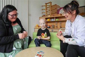 Der fünfjährige Bruno kämpft gegen den Krebs - Bei Uno haut er sie alle weg: Bruno nimmt es beim Kartenspiel im Spielzimmer der Kinderonkologie gern mit Mutter Denise Müller (links) und Psychologin Kristin Brandl auf. Im nächsten Jahr soll der heute Fünfjährige eingeschult werden. Etwa eins von 100.000 Kindern erkrankt an Krebs.