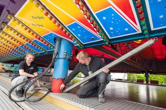 Der große Pfingstrummel beginnt: Das ist neu beim Plauener Vogelschießen 2026 - Mit seinen Mitarbeiterin Michelle Hasche baut Felix Hickmann den Autoscooter auf. Dort findet am Pfingstmontag ein Gottesdienst statt.