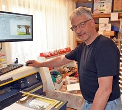 Der Holzpokal-Macher von Cämmerswalde - Matthias Bilz in seiner Werkstatt in Cämmerswalde. Mit einem speziellen Hochleistungsdrucker kann er Bildmotive auf dünne Holzplatten aufdrucken.