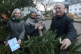 Der lebende Adventskalender von Ellefeld: Geliehene Buttonmaschine macht den Anfang - Die Ideengeber Anke Kowitz, Laura Krauß mit Tochter Ylvi stehen mit Bürgermeister Jörg Kerber (von links) am Tannenbaum).