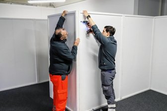 Der Letzte räumt das Impfzentrum auf - Erik Beitzel (r.) und Heinz-Michael Kirsten bei der Demontage der Trennwände im Impfzentrum.