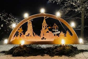 Der neue Schwibbogen in Brockau: Unikat erleuchtet die Ortsmitte - Der erleuchtete nagelneue Schwibbogen in Brockau misst fünf Meter in der Breite und gut zwei Meter in der Höhe. Das Motiv ist dreidimensional und zeigt die Brockauer Kirche und den Kuhbergturm.