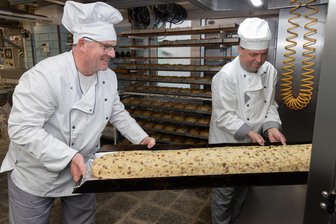 „Der Stollenanschnitt zum Weihnachtsmarkt ist unsere Ladenverkostung“ – Wo gibt’s im Erzgebirge den leckersten Stollen? - Konditormeister Frank Graupner und Mario Hengst (r.) haben den Riesenstollen in den Ofen geschoben. Das zwei Meter lange Exemplar wird beim Thumer Weihnachtsmarkt angeschnitten.