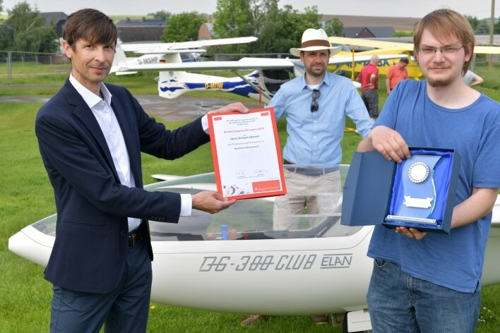 Der Überflieger mit einem Hang zur Bodenhaftung - Dirk Helbig (l.) aus dem Sparkassenvorstand übergibt Michael Aßmann (r.) den Ehrenamtspreis aus dem Jahr 2020. 