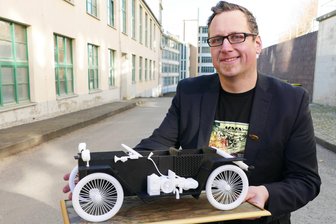 Der Ursprung von DKW und MZ: Wie ein Auto die Zschopauer Motorradproduktion ins Rollen brachte - Vor der Werkshalle, vor der 1919 eines der beiden noch vorhandenen Fotos mit dem Original aufgenommen wurde, präsentiert Mathias Meyer sein Modell des kleinen Bergsteigers.