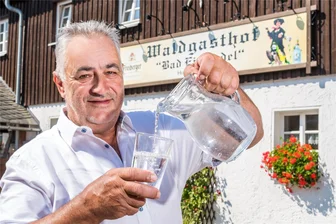 Der Vision vom Kurbad so nah: Seiffener bekommt Heilquelle anerkannt - Jetzt auch staatlich anerkannt: Michael Weidensdorfer schenkt ein Glas Wasser aus der Heilquelle auf seinem Grundstück ein.
