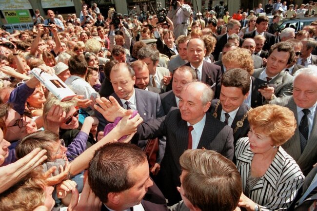 Der Wegbereiter: Michail Gorbatschow ist tot - ein Nachruf - Gorbatschow und seine Frau Raissa inmitten einer Menschenmenge auf dem Bonner Marktplatz am 13. Juni 1989. 
