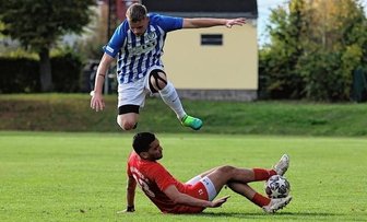 Derbysieger: TV Oberfrohna bleibt an der Tabellenspitze - Artistische Spielszene im Stadtduell: Jeremy Michel Porstmann vom TV Oberfrohna überspringt FSV-Kicker Yassine Boussif.