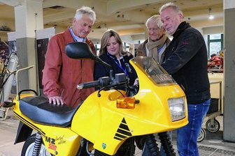 Deutsches Enduro-Museum Zschopau: Flair der Produktionszeiten blüht in MZ-Halle wieder auf - Der ehemalige Schlosser Fred Meyer, Museumsmitarbeiterin Dajana Kunze, der frühere Konstruktionsleiter Franz Wolf sowie der einstige Chefkonstrukteur Bernd Baumgartl (von links) beim Fachsimpeln. Hier schauen sie sich eine MZ 500 Country an, in die ein Rotax-Motor integriert war.