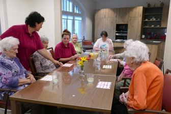 Diakonie eröffnet neue Tagespflege - Dreh- und Angelpunkt in der neuen Tagespflege ist der Gemeinschaftsraum mit Küche. Hier spielen die Pflege- und Betreuungskräfte Nancy Schmidt (2. v. l.) und Antje Wagner (4. v. l.) unter anderem mit den Gästen der Einrichtung.