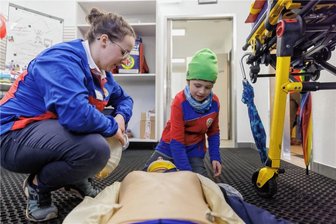 Die Bergretter vom Fichtelberg haben nun eine moderne Wache - Emma Gehler gehört zu den 30 aktiven Einsatzkräften der Bergwacht Oberwiesenthal - hier zeigt sie Julius im Sanitätsraum der Bergwacht, wie man einem verletzten Skifahrer eine Halskrause anlegt.