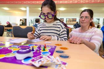 Die bunte Welt der Spiele in Limbach-Oberfrohna: Warum es beim Gesellschaftsspiel nicht immer ganz ehrlich zugeht - Schummelversuch: Mia Steinbrückner schaut beim Spiel „Verblickt“ an der Brille vorbei, die ihr eigentlich das Sehen erschweren soll.