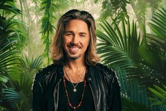 Die Dreck fressen: Warum uns das „Dschungelcamp“ als Straflager für Stars wie Gil Ofarim erfreut - Echter Star vor KI-generiertem Dschungel: Gil Ofarim.