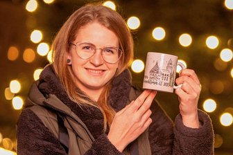 Die Entscheidung ist gefallen: So sieht die Plauener Glühweintasse im nächsten Jahr aus - Wiebke Knüpfer mit der sandfarbenen Siegertasse.