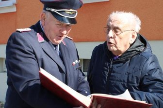 Die erste Frauenlöschgruppe der DDR kam aus Hartmannsdorf - Wehrleiter Dietmar Pansa (l.) und Werner Frenzel, der die Frauenlöschgruppe 1954 mit ins Leben gerufen hat, blättern in der Chronik.