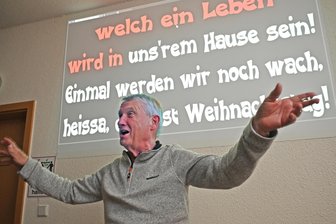 Die Fußballhelden aus dem Erzgebirge und ihr besonderes Weihnachtsritual - Chorleiter für einen Abend: Steffen Pannach vor der Karaoke-Bildwand.