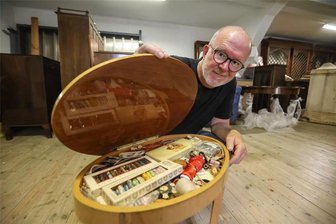 Die gute Stube der Gold-Trainerin: Ganzes Zimmer von Jutta Müller wandert in Chemnitz ins Museum - Der stellvertretende Leiter des Schloßbergmuseums Peer Ehmke zeigt das Nähkästchen, aus dem beim Öffnen eine Spieluhr erklingt. Dort bewahrte Jutta Müller ihre Stick-Utensilien auf. Im Hintergrund stehen die Art-déco-Möbel aus ihrer Wohnung.