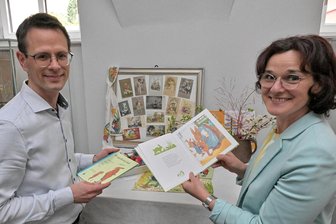 „Die Häschenschule“ auf Sächsisch: Zwickauer Land startet Übersetzungswettbewerb zum Kinderbuch-Klassiker - Kirchbergs Bürgermeisterin Dorothee Obst und Stefan Czarnecki, Vorsitzender des Vereins „Zukunftsregion Zwickau“ in der Osterausstellung im Meisterhaus Kirchberg. Dort sind etliche Exemplare der Häschenschule ausgestellt.