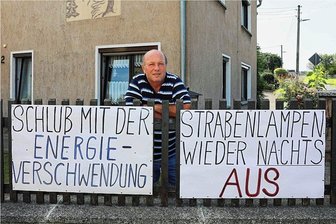 Die Laterne direkt vorm Schlafzimmer: Wie ein Trünziger sich seit Jahren gegen Beleuchtung in der Nacht wehrt - Stephan Wolf tut seine Meinung in Sachen Energieeinsparung mit Plakaten an seinem Grundstück kund.