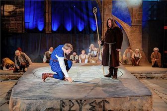 Die Lösung des Artus-Rätsels: Was die Runen auf der Plauener Parktheater-Bühne bedeuten - Friedrich Rau (links) als künftiger König Artus auf der großen Sonnenrune. Vorn am Stein sind fünf weitere Zeichen mit Bedeutung zu sehen.