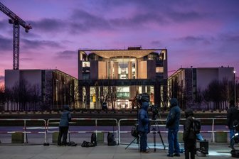Die Luft wird dünn für die Ukraine - Medienvertreter stehen im Abendlicht vor dem Bundeskanzleramt. Im Kanzleramt beraten der ukrainische Präsident Selenskyj, seine Unterhändler und die US-Delegation zunächst unter sich.