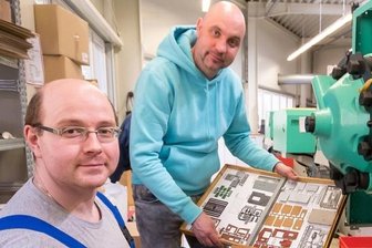 Die neue Lust am Modellbau: Auhagen aus Marienberg steigert Umsatz deutlich - Geschäftsführer Markus Hillig (rechts) kontrolliert mit Mitarbeiter Maik Reichel an einer der Spritzgussmaschinen gefertigte Bauteile. Sie bilden das Modell eines Sägewerks.