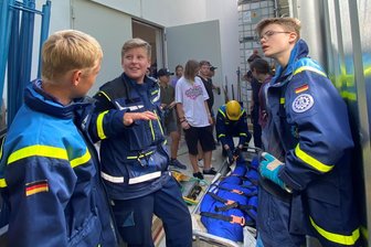 Die Reichenbacher THW-Jugend zeigt Falkensteiner Kindern, was sie draufhat - ein Besuch bei dieser Jugend von heute - Mit Begeisterung und Einsatz bei der Sache. Die Reichenbacher THW-Jungspunde um Theo Trautmann (Mitte) binden die jungen Gästen aus Falkenstein (hinten) in die simulierte Bergung einer verunglückten Person ein. Die Puppe im sogenannten Schleifkorb bringt immerhin 80 Kilogramm auf die Waage.