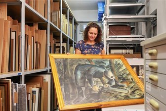 Die ungehobenen Schätze der Wismut schlummern im Chemnitzer Depot - Anja Richter, Teamleiterin im Archiv der Wismut, mit einem Gemälde von 1951.