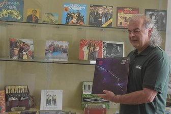 „Die Welt in Vinyl“: Neue Ausstellung in Zwota - Im Harmonikamuseum Zwota wird eine Sonderausstellung unter dem Titel "Die Welt in Vinyl" gezeigt. Sie wurde von Thorald Meisel gestaltet. Das Foto zeigt ihn mit einer litauischen Pressung des Dire-Straits-Albums "Love Over Gold".