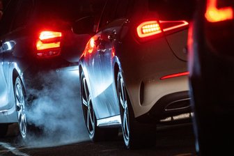Die Zukunft ist elektrisch - Autoabgase sind hinter einem Kraftfahrzeug im Straßenverkehr zu sehen.