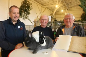Dieser Verein hat zwei Weltkriege und die DDR überlebt: Weischlitzer Kleintierzüchter feiern Jubiläum - Thomas Tschanter (links) und Fridhold Roth zeigen rassige Kaninchen: Blauer Wiener und Holländer schwarz-weiß. Werner Walther hält das Protokoll der Vereinsgründung vom 28. Juli 1900 in den Händen.